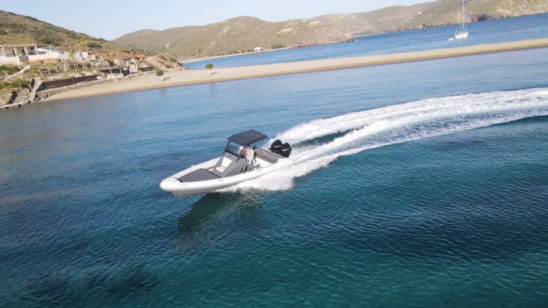 Island hopping — the Ploistos RIB underway past a Saronic islet, aerial view